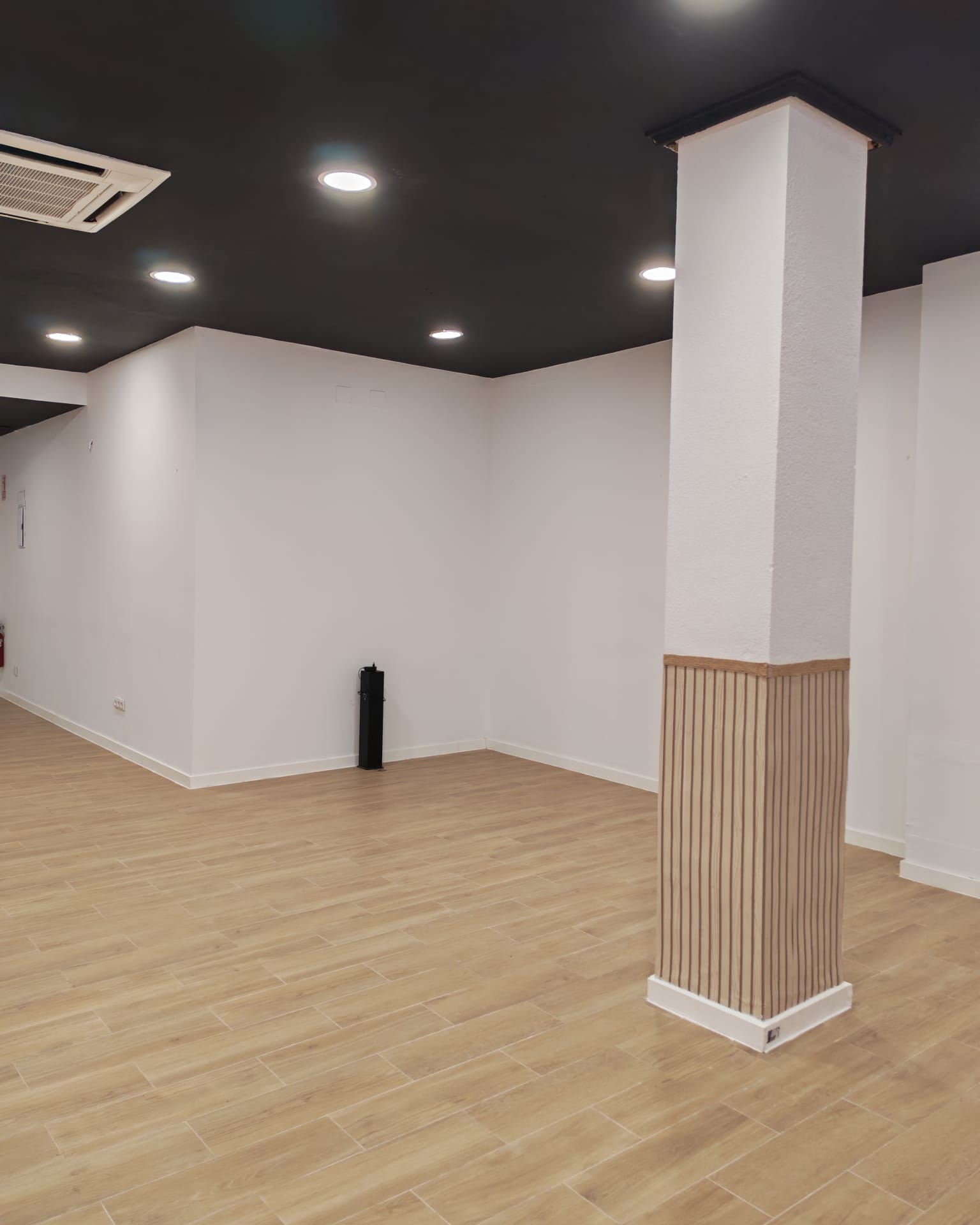 Sala amplia con columna y suelo de madera